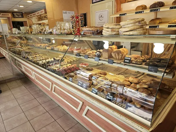 Vue d'ensemble de la vitrine réfrigérée et des étagères à pain derrière le comptoir.